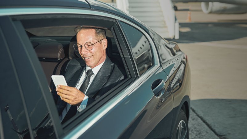 A man with a smartphone sitting in the car